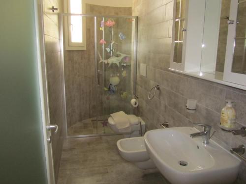 ein Bad mit einem Waschbecken, einem WC und einer Dusche in der Unterkunft Vivere nel Salento in Torre San Giovanni Ugento