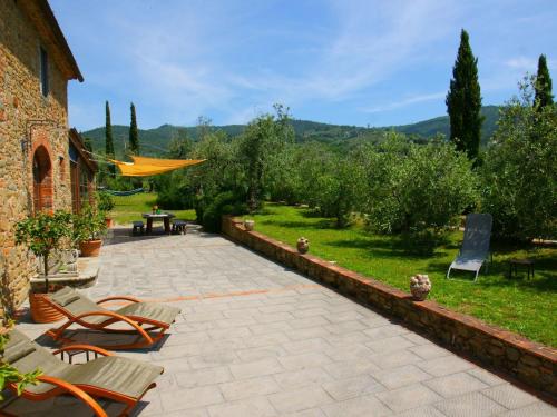 ヴィンチにあるBeautiful Holiday Home in Vinci with Swimming Poolの庭園内のパティオ(椅子、テーブル付)