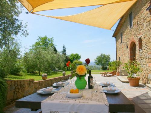 a table with a vase of flowers on a patio at Beautiful Holiday Home in Vinci with Swimming Pool in Vinci