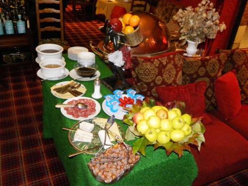 a table with a green table cloth with food on it at Cit'Hotel Marie Stuart in La Roche-sur-Yon