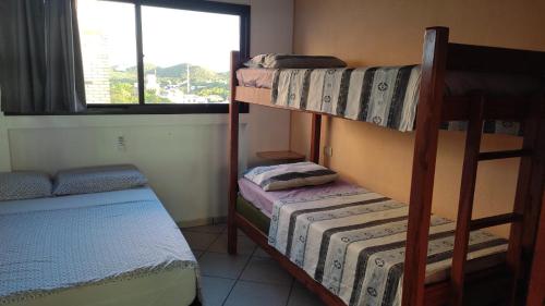 a room with two bunk beds and a window at Apto estilo chalé em Ponta Negra in Natal
