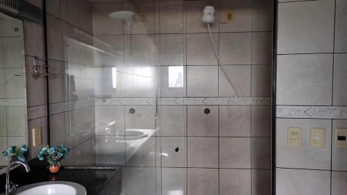 a bathroom with a shower with a sink and a sink at Apto estilo chalé em Ponta Negra in Natal