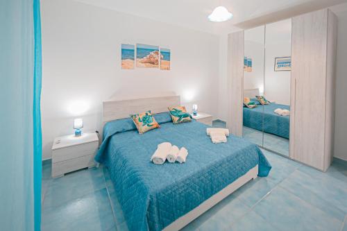 a bedroom with a blue bed and a mirror at Scinniamare in Cefalù