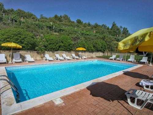 una gran piscina con sillas y sombrillas en Cozy Farmhouse in Paciano with Private Pool, en Paciano