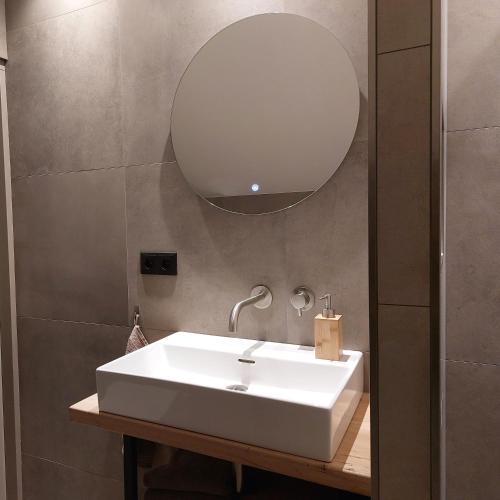 a bathroom with a white sink and a mirror at Vakantiehuis de Bakspieker in Haaksbergen