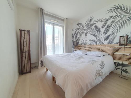 ein Schlafzimmer mit einem großen Bett und einer tropischen Tapete in der Unterkunft EXIGE HOME - Charmant 2 pièces Vue Tour Eiffel in Châtillon