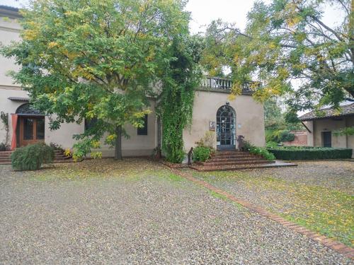 Una casa blanca con un árbol delante. en Quaint Mansion in Stagno Lombardo with Garden en Stagno Lombardo