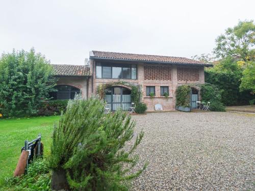 ein großes Backsteinhaus mit Kieseinfahrt in der Unterkunft Quaint Mansion in Stagno Lombardo with Garden in Stagno Lombardo