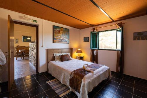 a bedroom with a large bed and a dining room at Ninho Da Poupa in Serpa