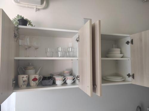 a cabinet filled with cups and plates and bowls at BRIGHT CITY CENTER Apartment - FlexibleCheckins in Zagreb