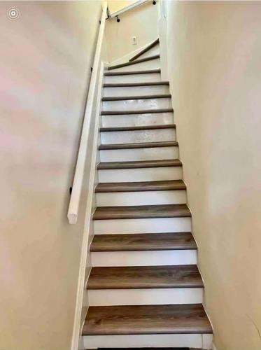 a staircase in a house with white walls and wooden floors at 8-A Diamond in Yonkers, NY in Yonkers