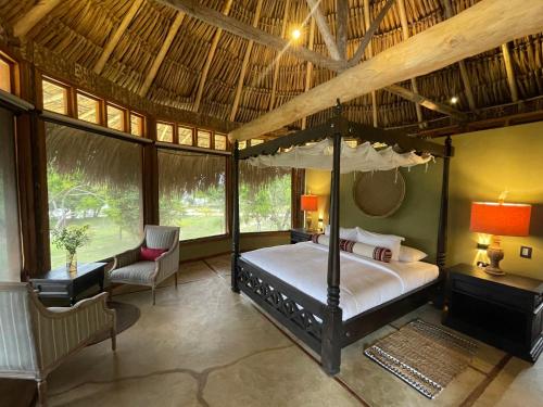 a bedroom with a canopy bed in a room with windows at Waka Wená in Santa Elena de Uairén
