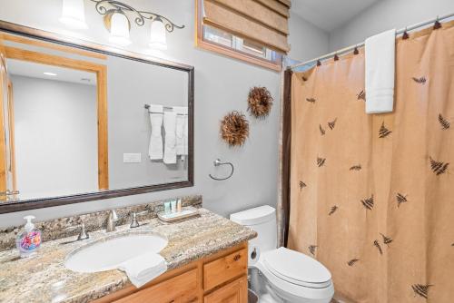 a bathroom with a sink and a toilet and a mirror at Summit Condo - Luxury condo, walk to the slopes! in Big Bear Lake