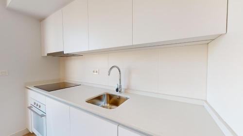 una cocina con armarios blancos y fregadero en Alicante Colorful Penthouse Center 5C, en Alicante