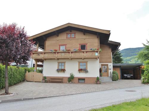 una casa di legno con una panchina di fronte di Cosy apartment with garden in Salzburger Land a Walchen