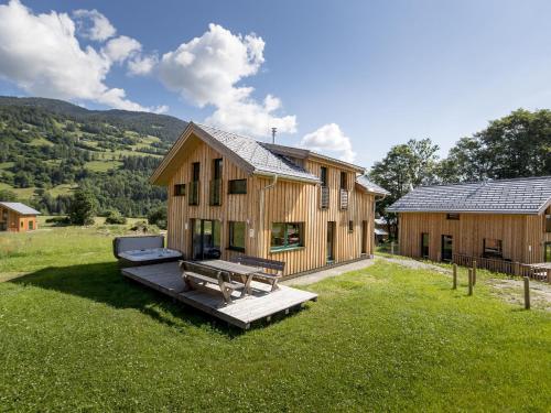 a wooden house with a bench in the yard at Wooden Chalet in Sankt Georgen ob Murau with Sauna in Sankt Lorenzen ob Murau