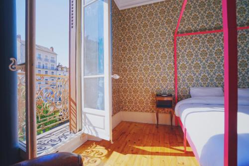 um pequeno quarto com uma cama e uma janela em Estacart - Grenoble Centre em Grenoble