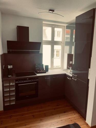a kitchen with a black stove and a window at BySeyn - 60qm mitten in der Erfurter Altstadt in Erfurt