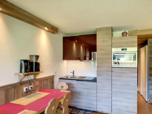 - une petite cuisine avec une table et un comptoir dans l'établissement Studio rénové skis aux pieds avec balcon sud, 4 pers, garage inclus - FR-1-178-375, aux Menuires