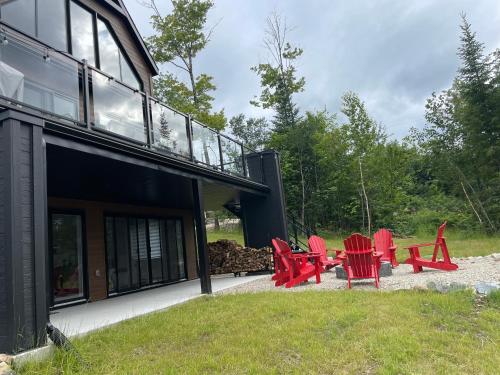 a group of red chairs sitting outside of a house at Au Coin Du Belvédère in Saint Come
