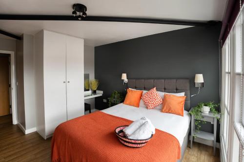 a bedroom with a large bed with an orange blanket at High Street Town House in Manchester