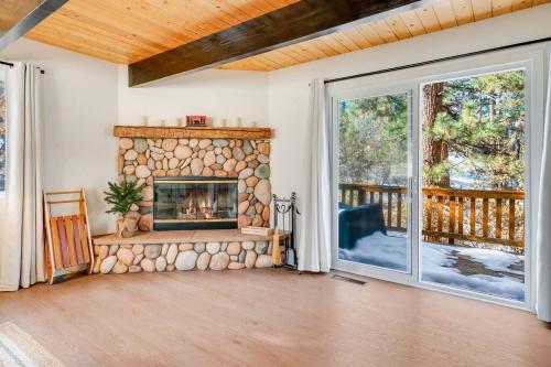 an empty living room with a stone fireplace at Pine Den Cabin: Arcade+Fire Pit+BBQ in Sugarloaf