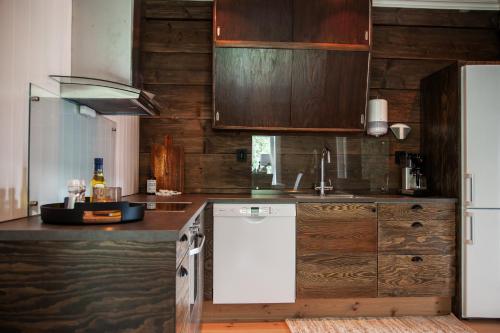 a kitchen with a white refrigerator and wooden cabinets at Tuftegarden in Viksdalen