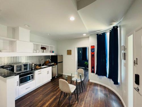 a kitchen with white cabinets and a table and chairs at Sonsak - Unit 2 in Charlottesville