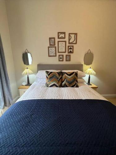 a bedroom with a large blue bed with two lamps at Luxury Victorian spacious flat in Glasgow