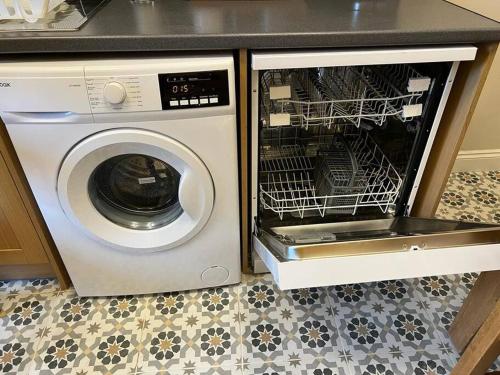 a washing machine with its door open in a kitchen at Luxury Victorian spacious flat in Glasgow