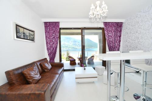 ein Wohnzimmer mit einem Sofa und einem Tisch in der Unterkunft Pearl Shell Apartments in Kotor
