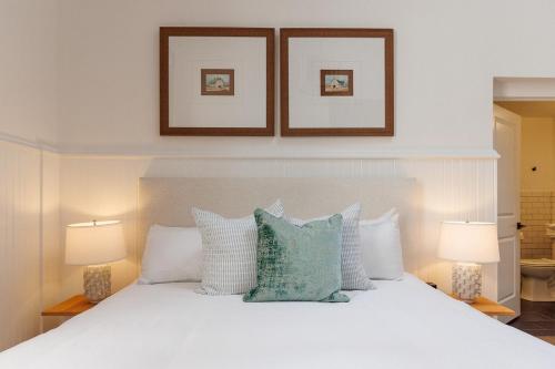 a bedroom with a white bed with pillows and two lamps at Fire Station One Boutique Hotel in Roanoke