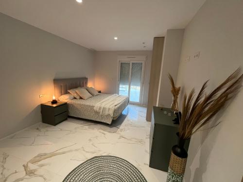 ein Schlafzimmer mit einem Bett und einem großen Marmorboden in der Unterkunft TERRAZA LA MARINA in Elche