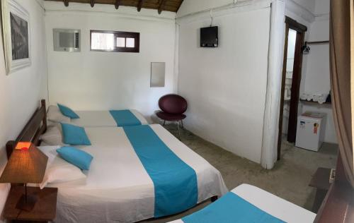 1 dormitorio con 1 cama grande con almohadas azules en Pousada Estalagem Paraty, en Paraty