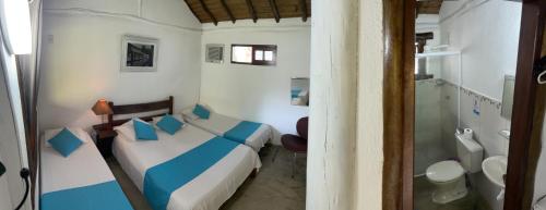 Habitación pequeña con 2 camas y baño. en Pousada Estalagem Paraty, en Paraty