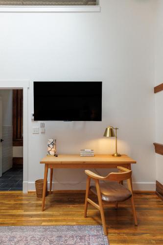 a desk with a chair and a television on a wall at Fire Station One Boutique Hotel in Roanoke