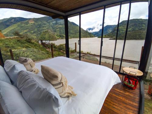 a bedroom with a bed and a view of a river at Summer C in Macanal
