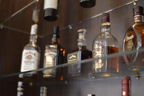 a group of bottles of alcohol sitting on a shelf at Hotel Miky in Arad