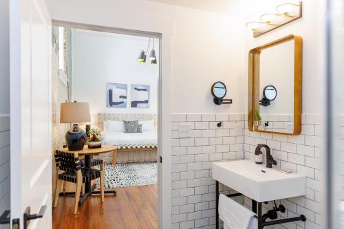 a bathroom with a sink and a mirror and a bedroom at Fire Station One Boutique Hotel in Roanoke