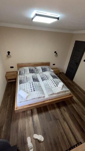 a bed in a room with two slippers on the floor at Penzion Loket in Loket