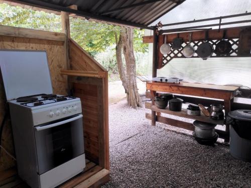 cocina al aire libre con fogones y parrilla en Отель Домик у реки Хипста en Gudauta