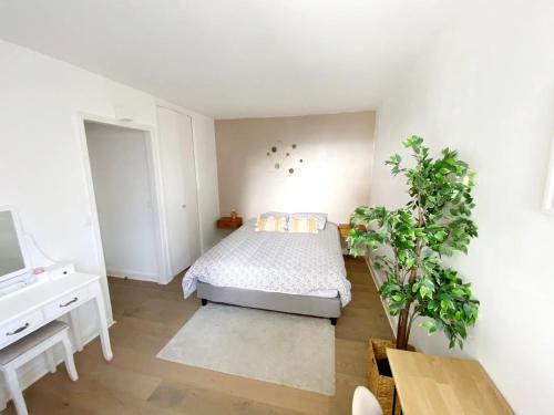 a white bedroom with a bed and a desk at LE COSY avec piscine, balcon et parking in Trouville-sur-Mer