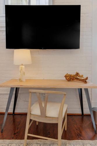 a desk with a television on a wall with a chair at Fire Station One Boutique Hotel in Roanoke