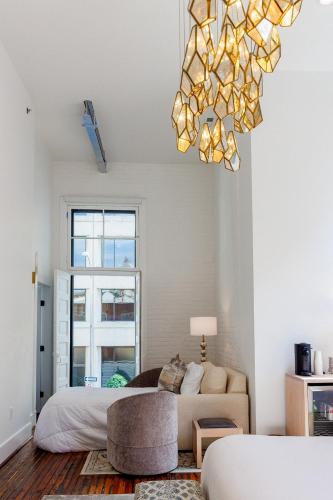a living room with a bed and a chandelier at Fire Station One Boutique Hotel in Roanoke