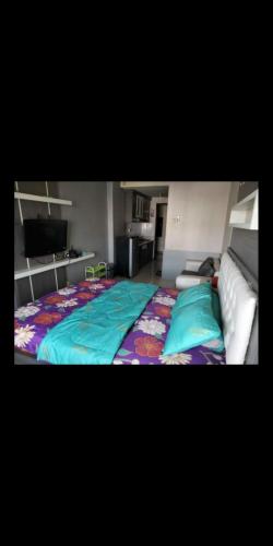 ein Schlafzimmer mit einem großen Bett und einem TV in der Unterkunft Apartemen suhat in Jenggrik