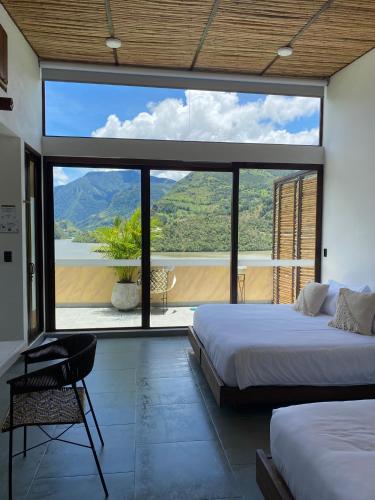 a bedroom with two beds and a large window at Summer C in Macanal