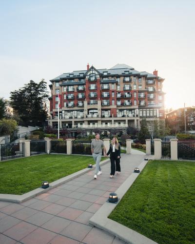 a man and a woman walking in a park with skateboards at Oak Bay Beach Hotel in Victoria