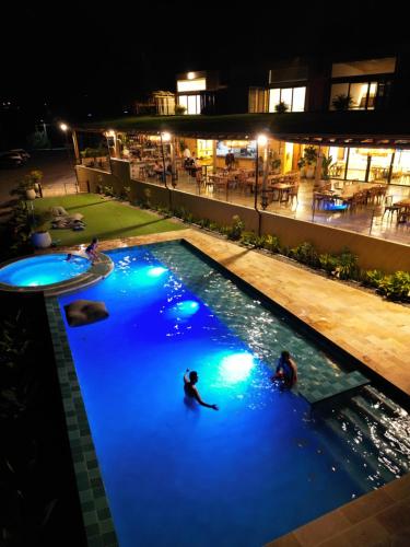 dos personas en una piscina por la noche en Summer C en Macanal