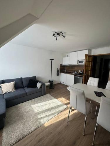 un salon avec un canapé bleu et une table dans l'établissement Studio cabine chaleureux, à Corrençon-en-Vercors