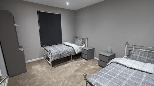 a bedroom with two beds and two night stands at Edge Stays 2 Bed Property in Leeds